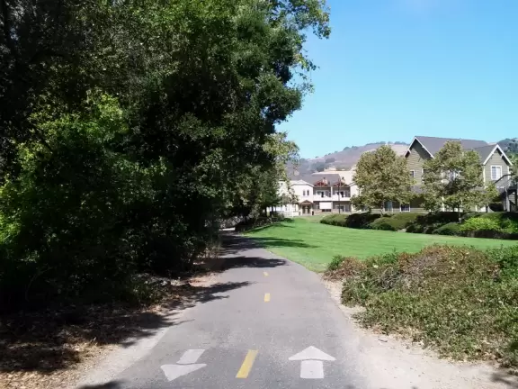 Wide partially shady path that leads through oak forest, past a market, and a Secret Garden with live music, to Avila Beach.