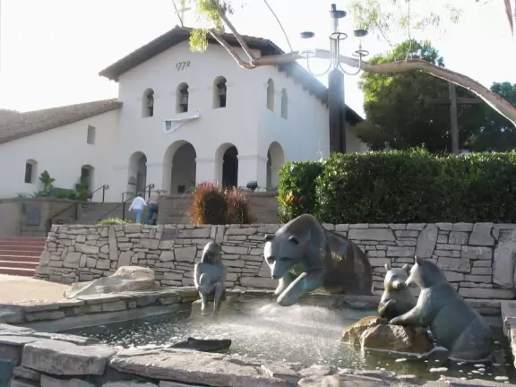 Spanish mission from late 18th century, in downtown San Luis Obispo, with giant roses in the garden behind and a lively plaza in front.